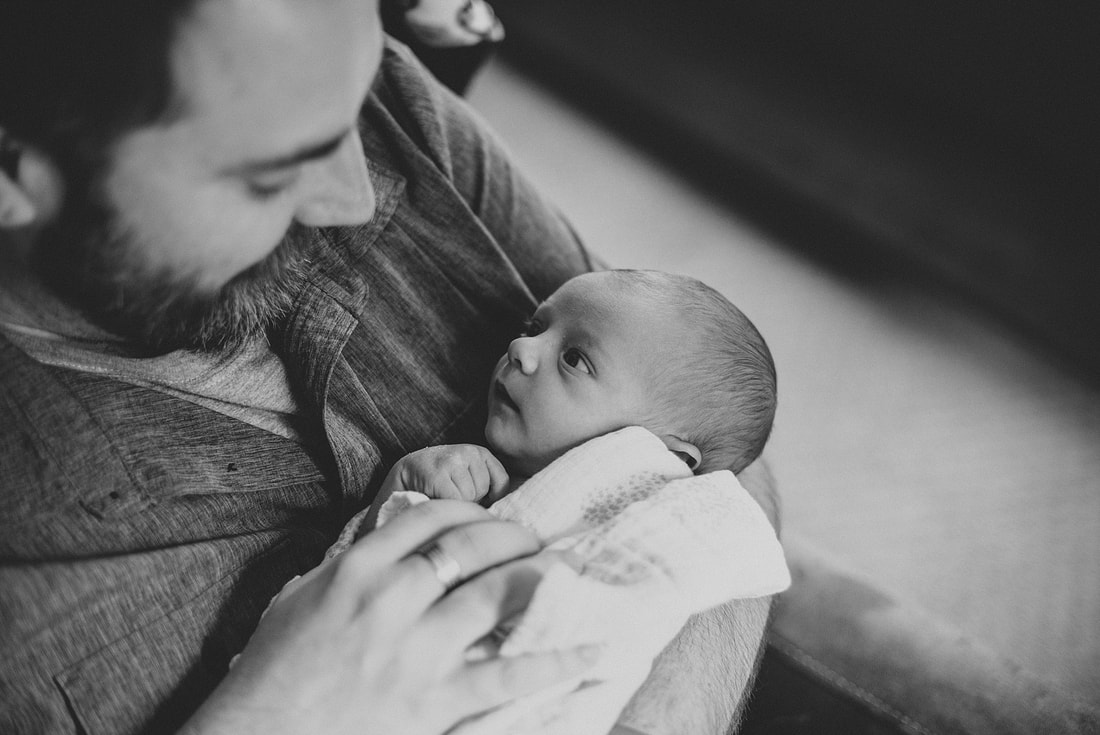 Black-and-white lifestyle portrait of a newborn baby boy and his dad by Laura Richards Photography