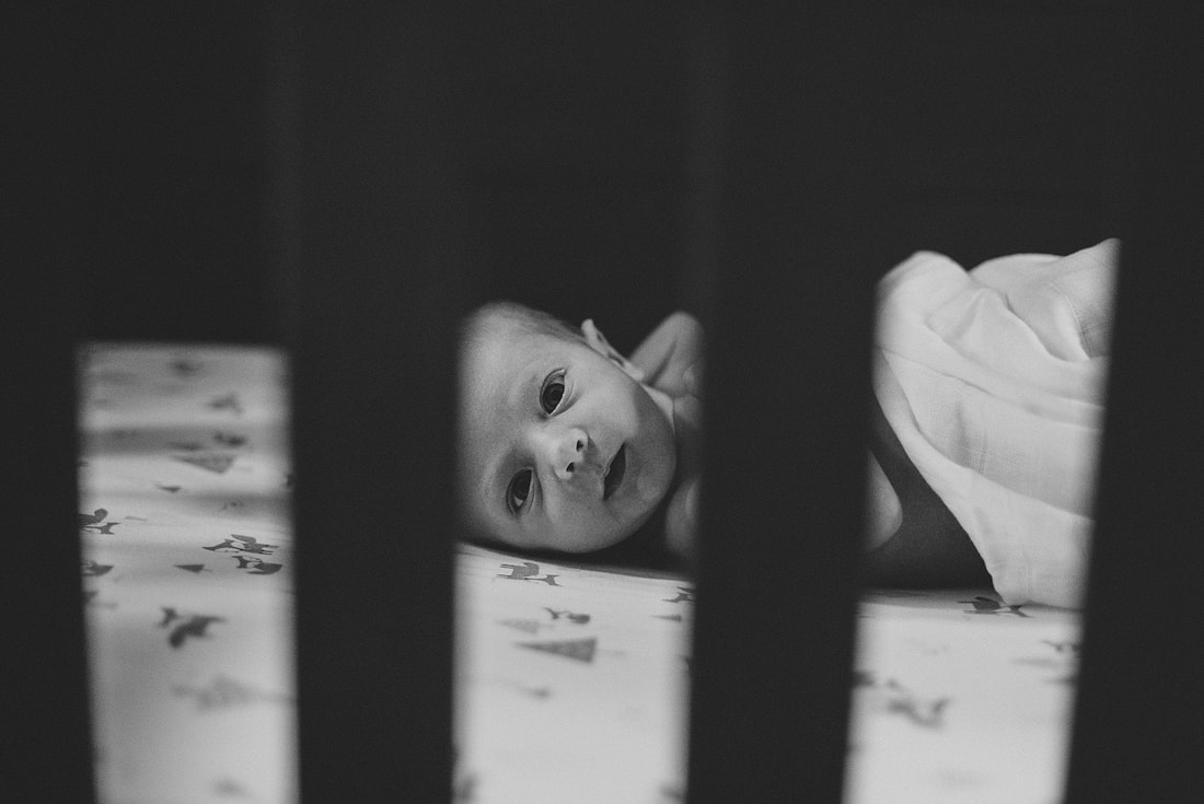 Alert baby boy in his crib during a lifestyle newborn session in Salem, Virginia by Laura Richards Photography