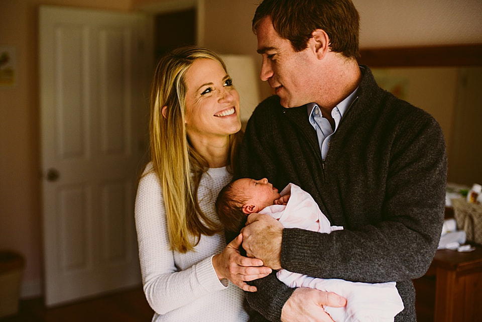 Happy new parents with their baby girl during an at-home newborn session in Roanoke, Virginia