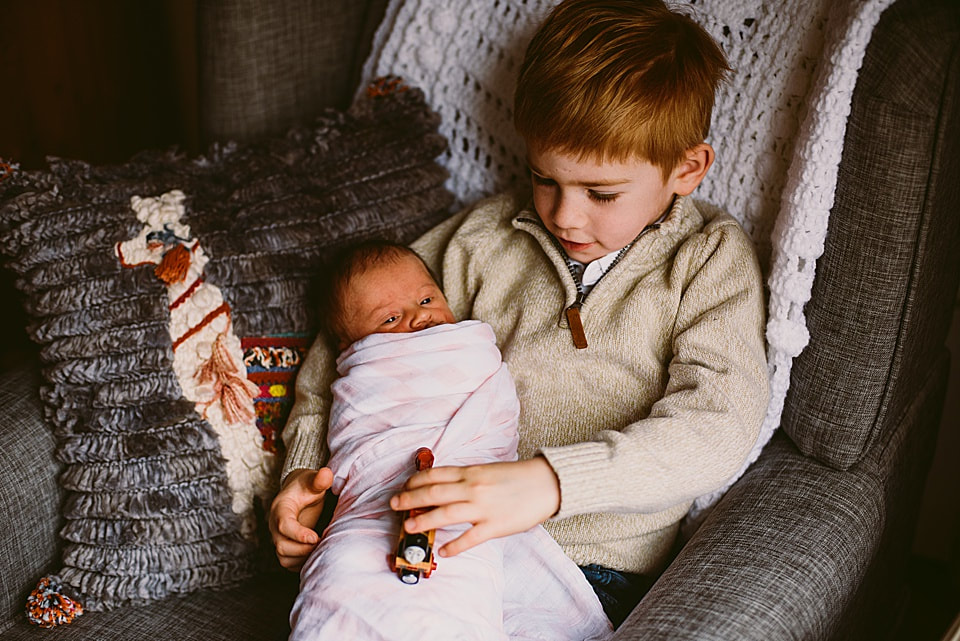 Big brother and his newborn sister during a lifestyle photography session at their Roanoke, Virginia home.